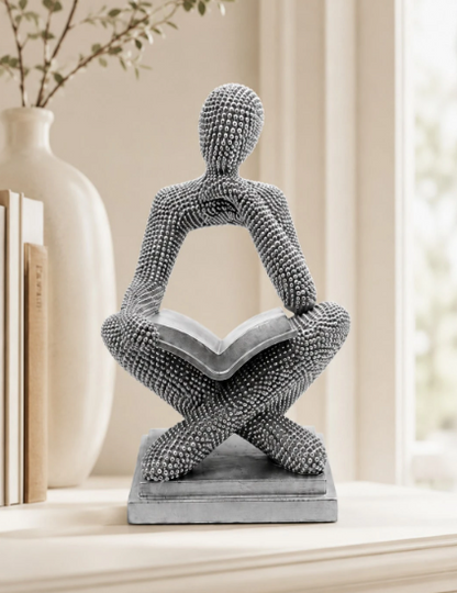 Objeto decorativo homem pensativo a ler