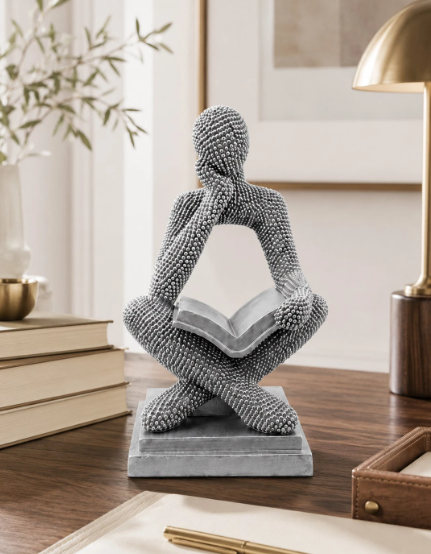 Objeto decorativo homem pensativo a ler